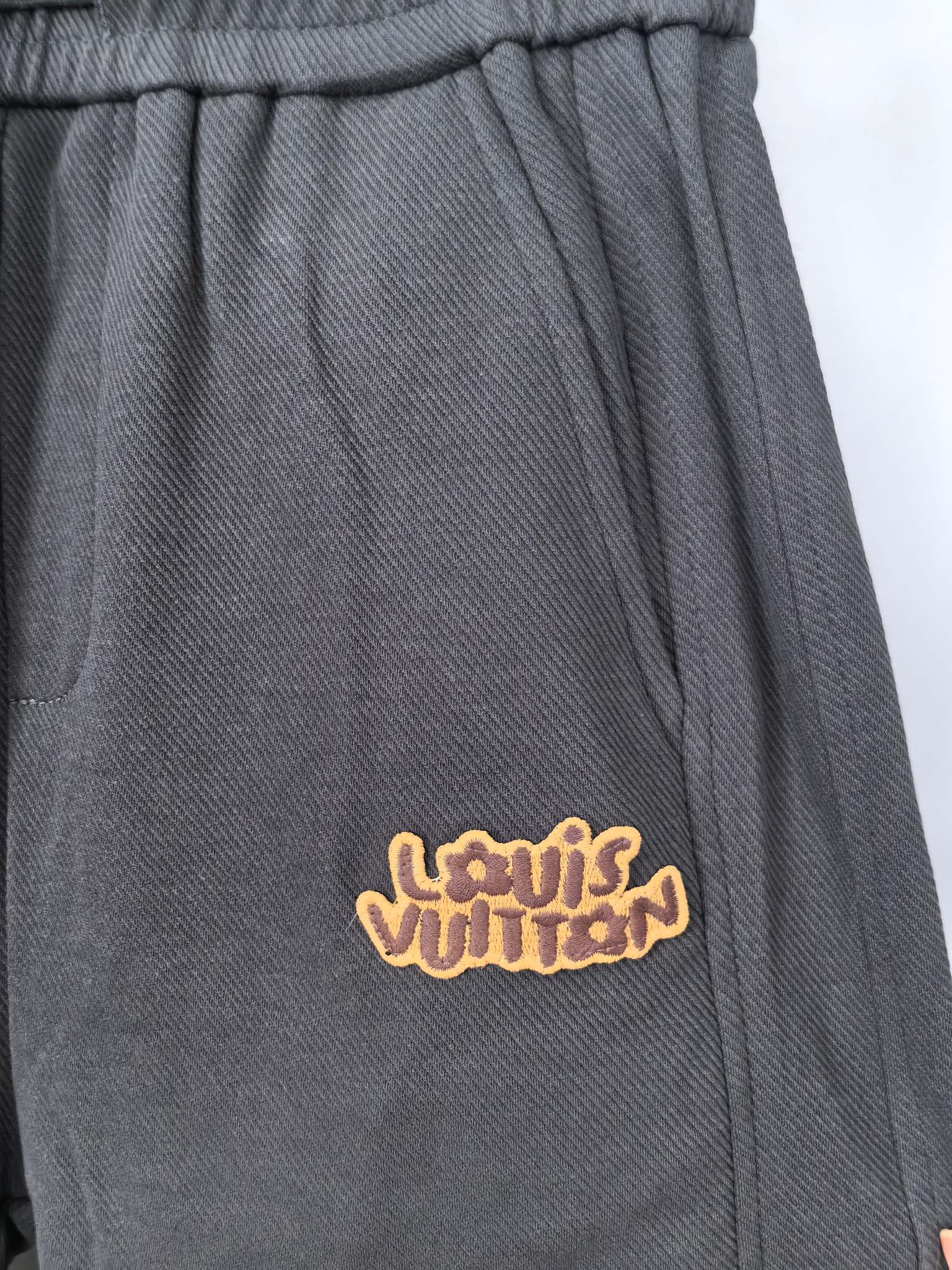 Dark gray Louis Vuitton jogger pants with embroidered logo on front pocket