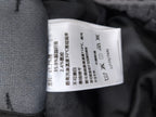 Dark gray Louis Vuitton pants care label with fabric composition and wash symbols