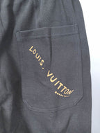 Dark gray Louis Vuitton jogger pants with gold-tone logo on front pocket