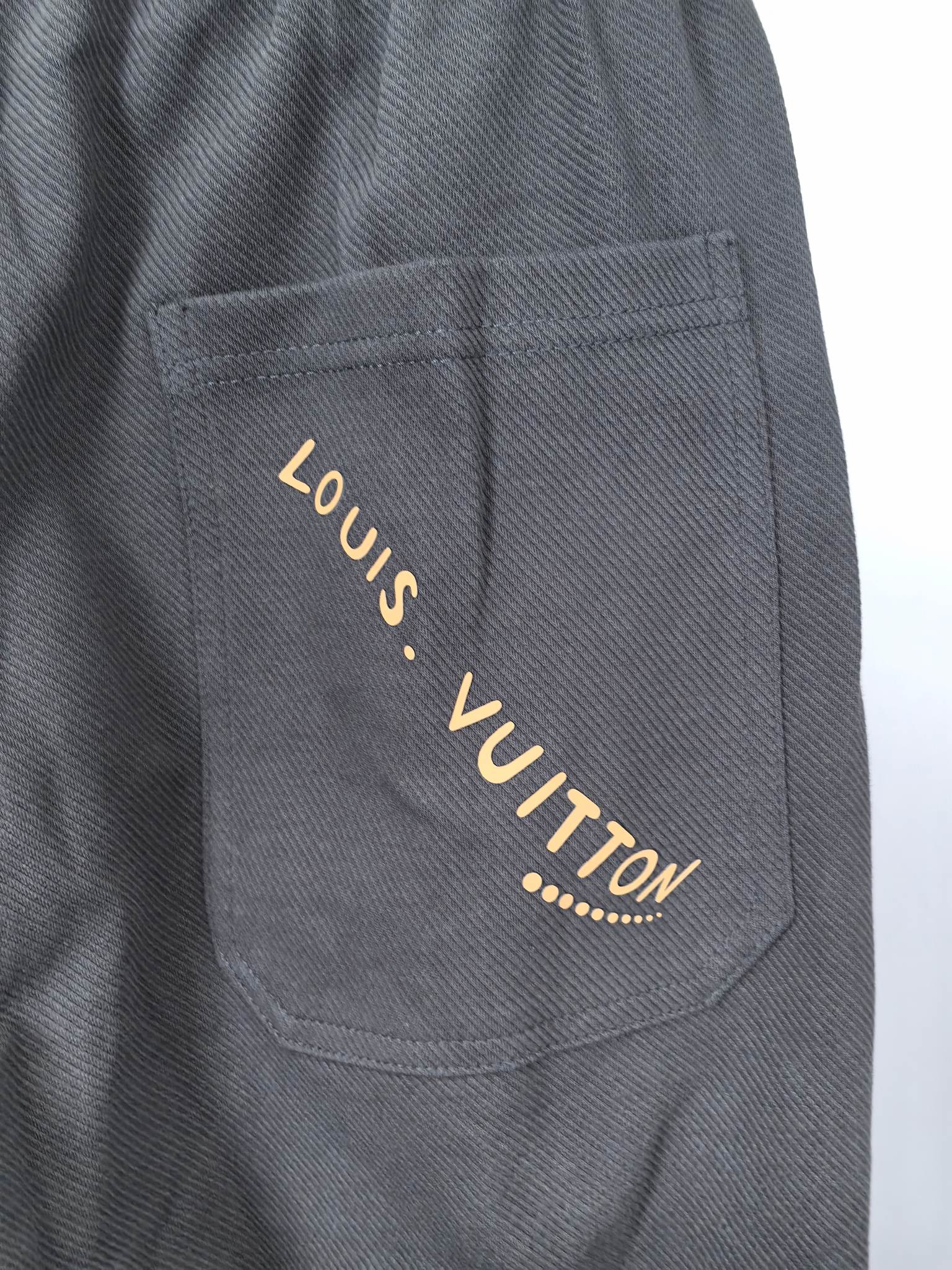 Dark gray Louis Vuitton jogger pants with gold-tone logo on front pocket