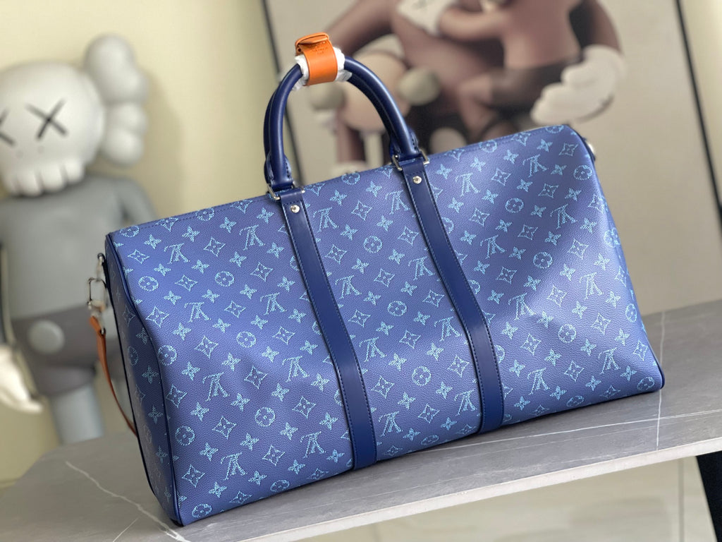 Blue Louis Vuitton duffel bag with monogram pattern, top handles, and orange trim details