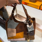 Tote bag with dark brown straps and multicolor patchwork; hanging tag and logo badge