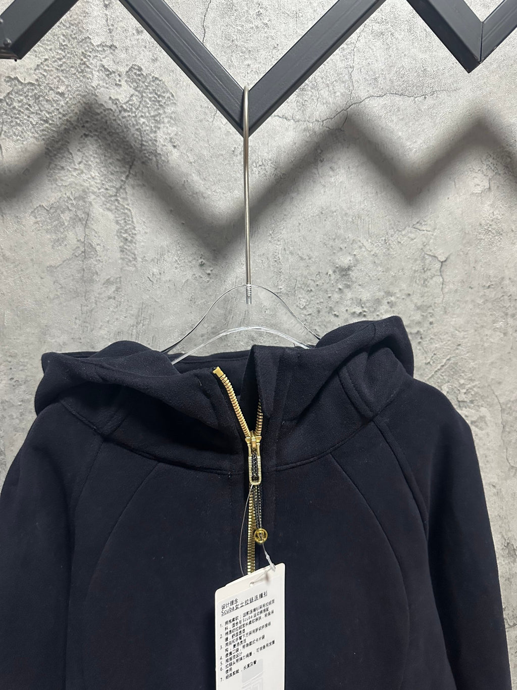 Dark zip-up hoodie hood with center zipper and gold zipper pull