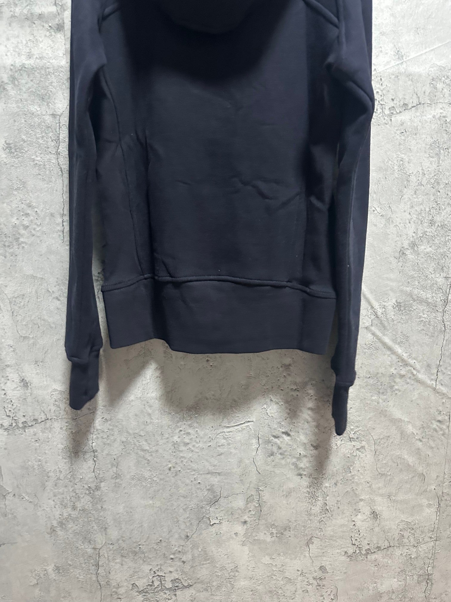 Dark zip-up hoodie with kangaroo pocket and zip front, close-up