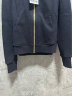 Dark zip-up hoodie front hem with gold zipper and ribbed cuffs