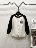 Black-sleeve white raglan cardigan with button front and chest crest patch.