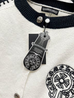 Ribbed navy neckline with metal snap buttons on white raglan cardigan.