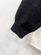 Knit black sleeve cuff and hem on white raglan cardigan.
