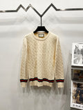 Cream cable-knit sweater with crew neck and multicolor striped hem and cuffs
