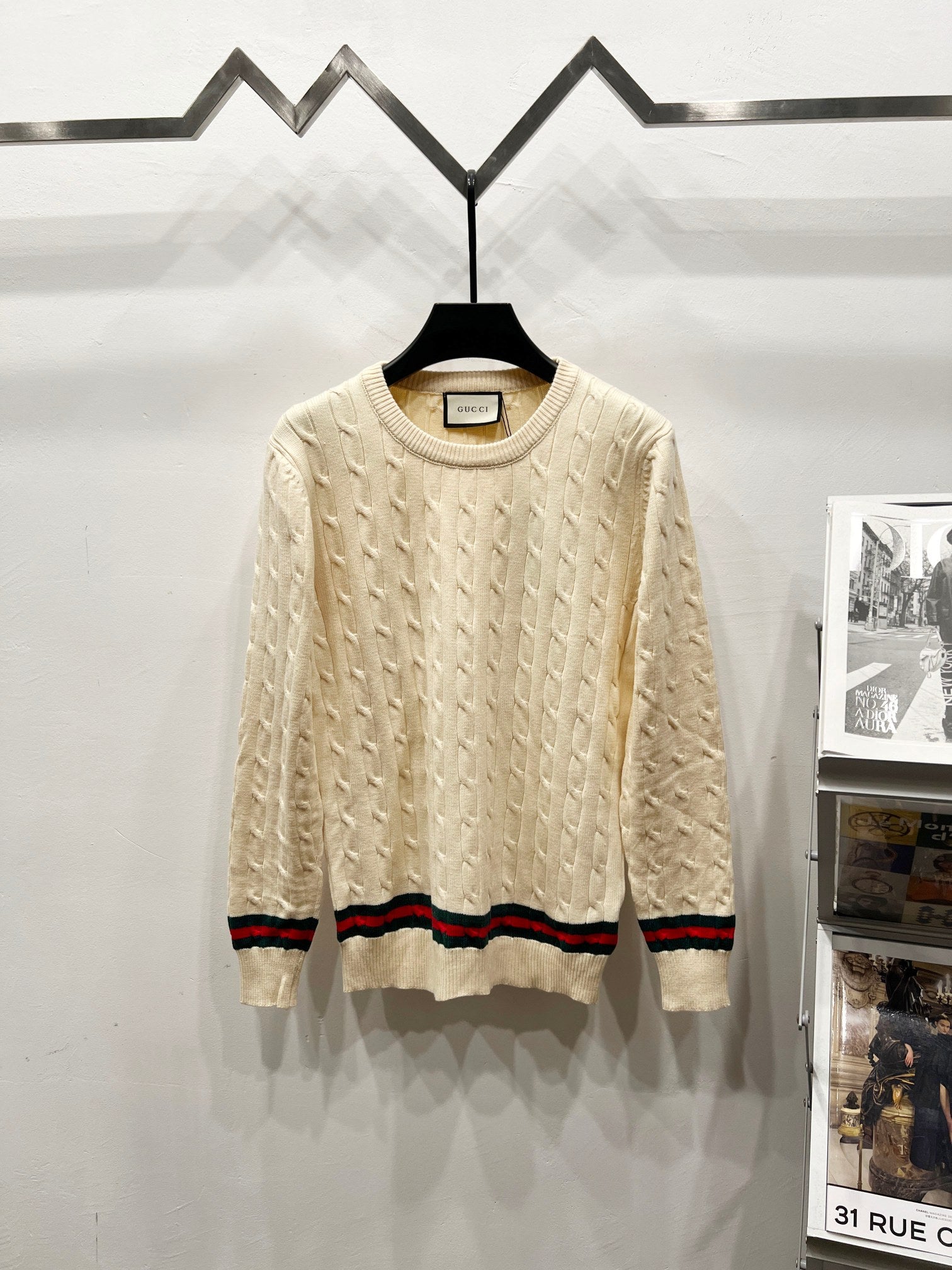 Cream cable-knit sweater with crew neck and multicolor striped hem and cuffs