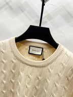 Cream cable-knit sweater neckline with Gucci label