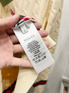 Cream sweater tag marked Gucci, size L, with care and fabric icons
