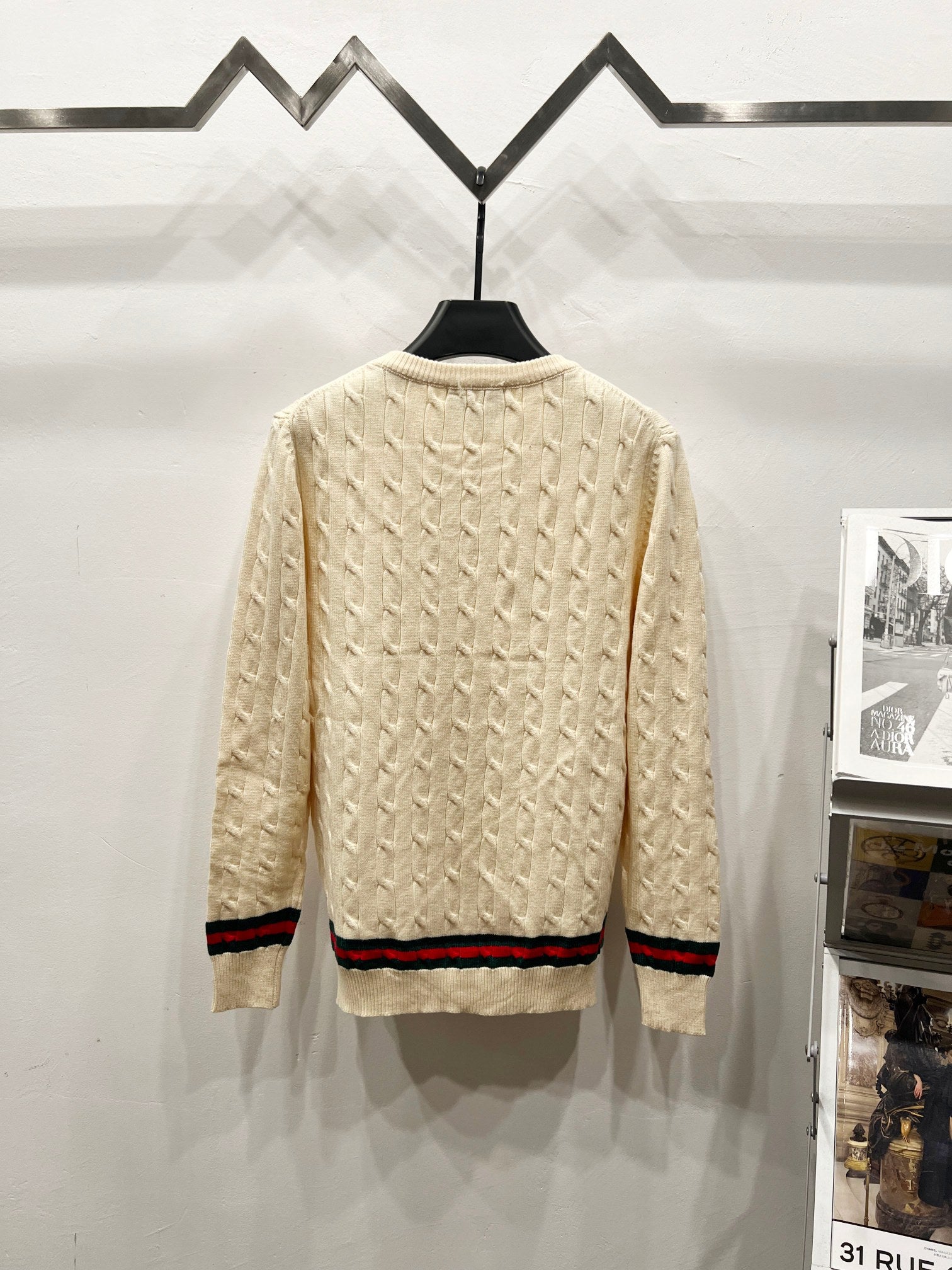 Cream cable-knit sweater, crew neckline, multicolor striped hem at back