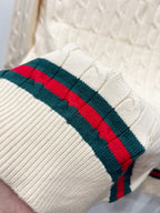 Cream knit sleeve cuff with red and green striped band