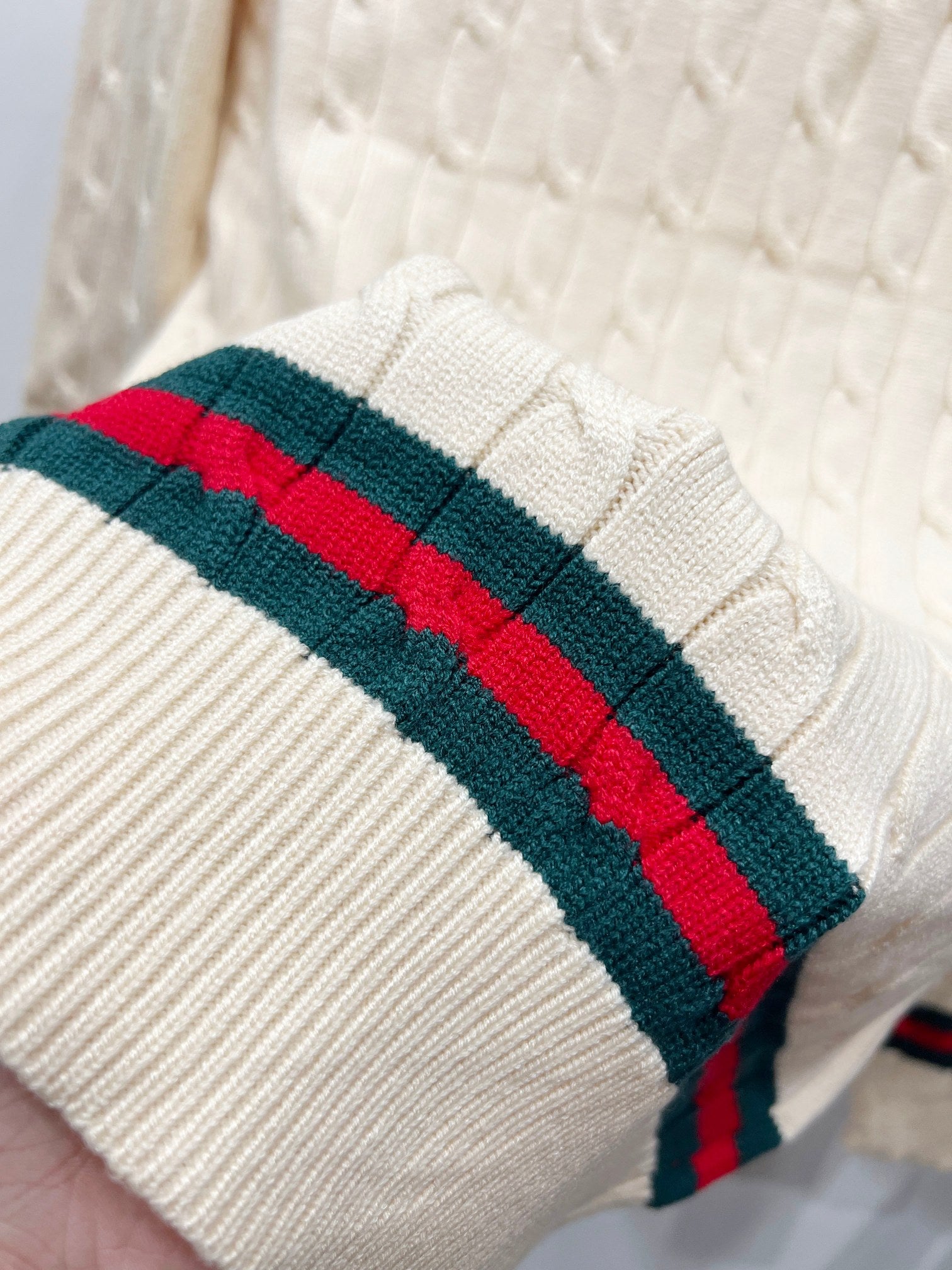 Cream knit sleeve cuff with red and green striped band