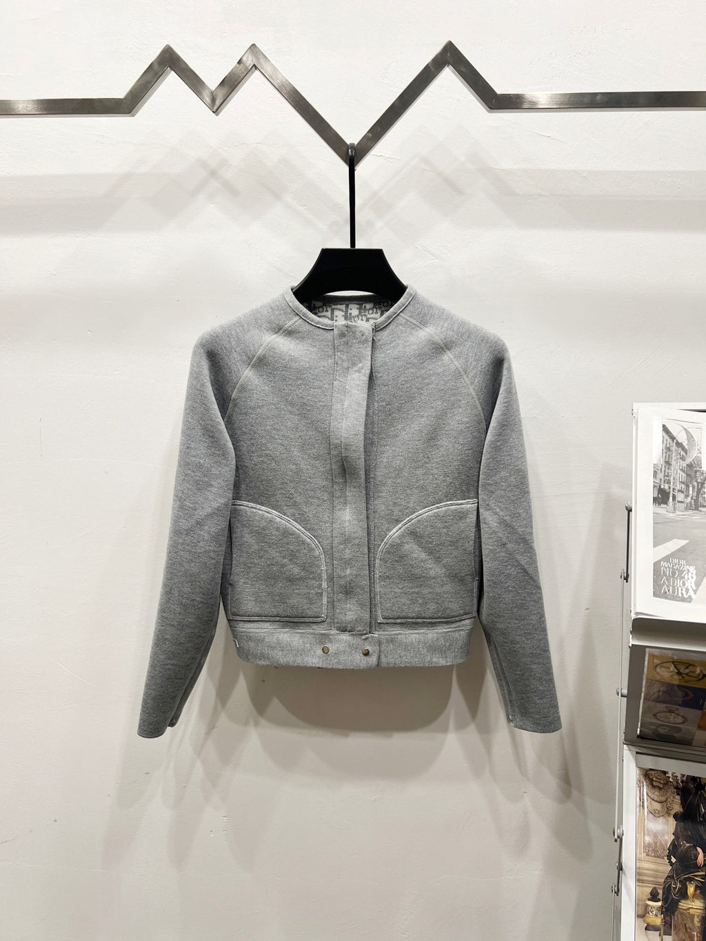Light gray zip-front knit jacket with panel seams and ribbed cuffs