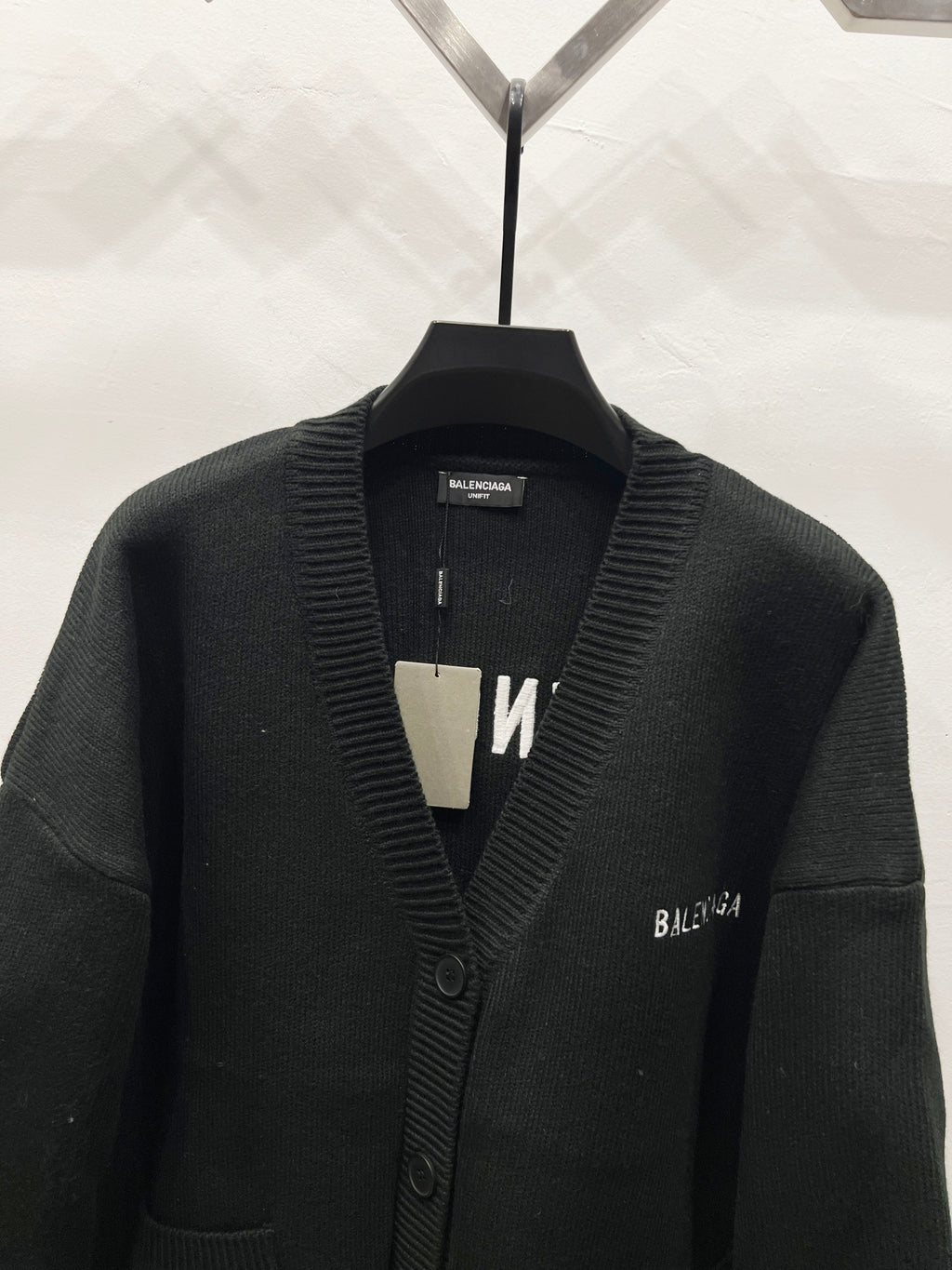 Balenciaga black knit cardigan close-up with ribbed V-neck and button placket