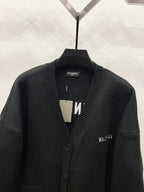 Balenciaga black knit cardigan close-up with ribbed V-neck and button placket