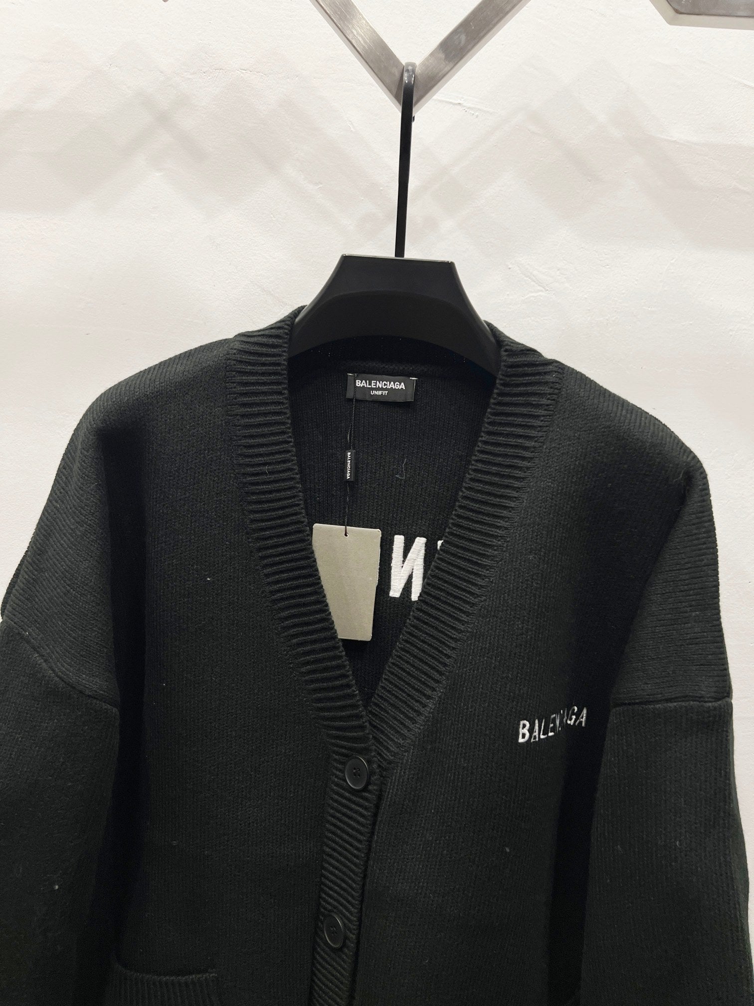 Balenciaga black knit cardigan close-up with ribbed V-neck and button placket