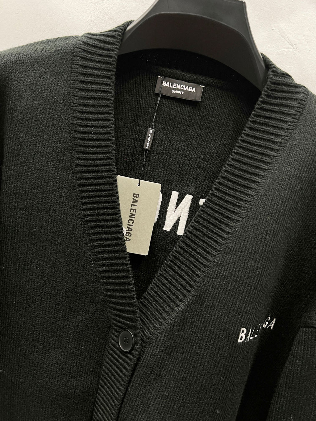 Balenciaga black knit cardigan detail with ribbed edge and front logo tag