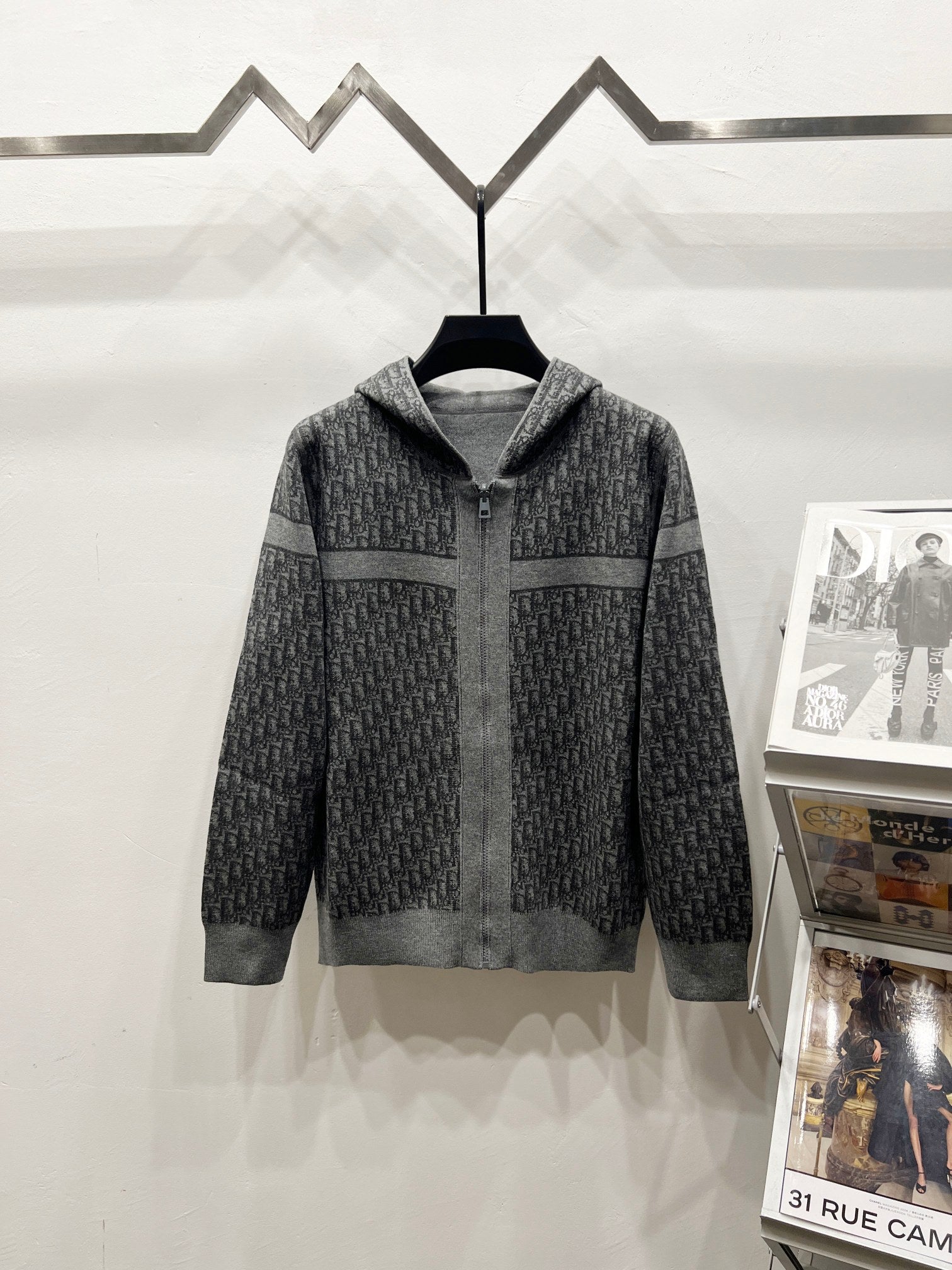 Grey patterned hooded zip jacket with dark side panel sections and ribbed hem