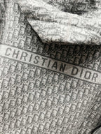 Close-up of grey fabric with Dior-style lettering pattern across the hood