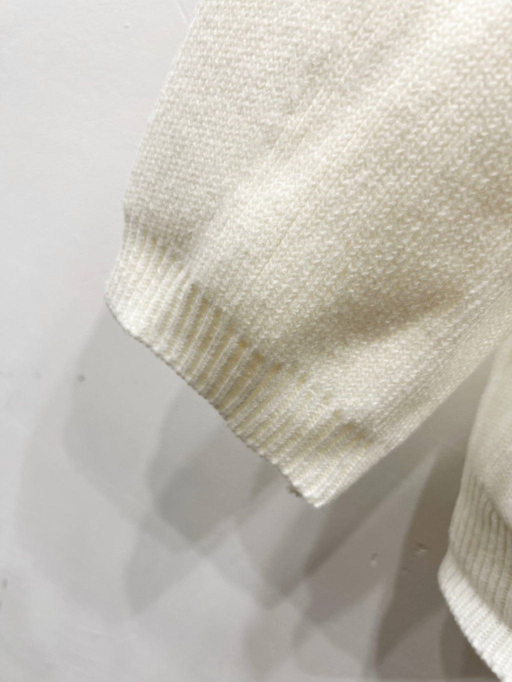 Cream knit cardigan sleeve cuff with textured knit detail