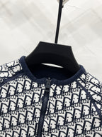 Close-up of black-and-white Dior logo zip jacket, knit collar and placket