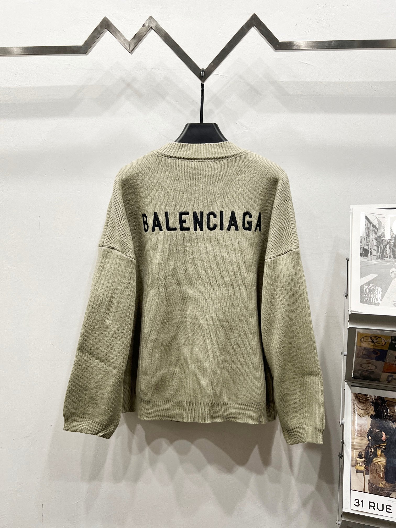 Beige knit cardigan with black BALENCIAGA text on back and ribbed collar