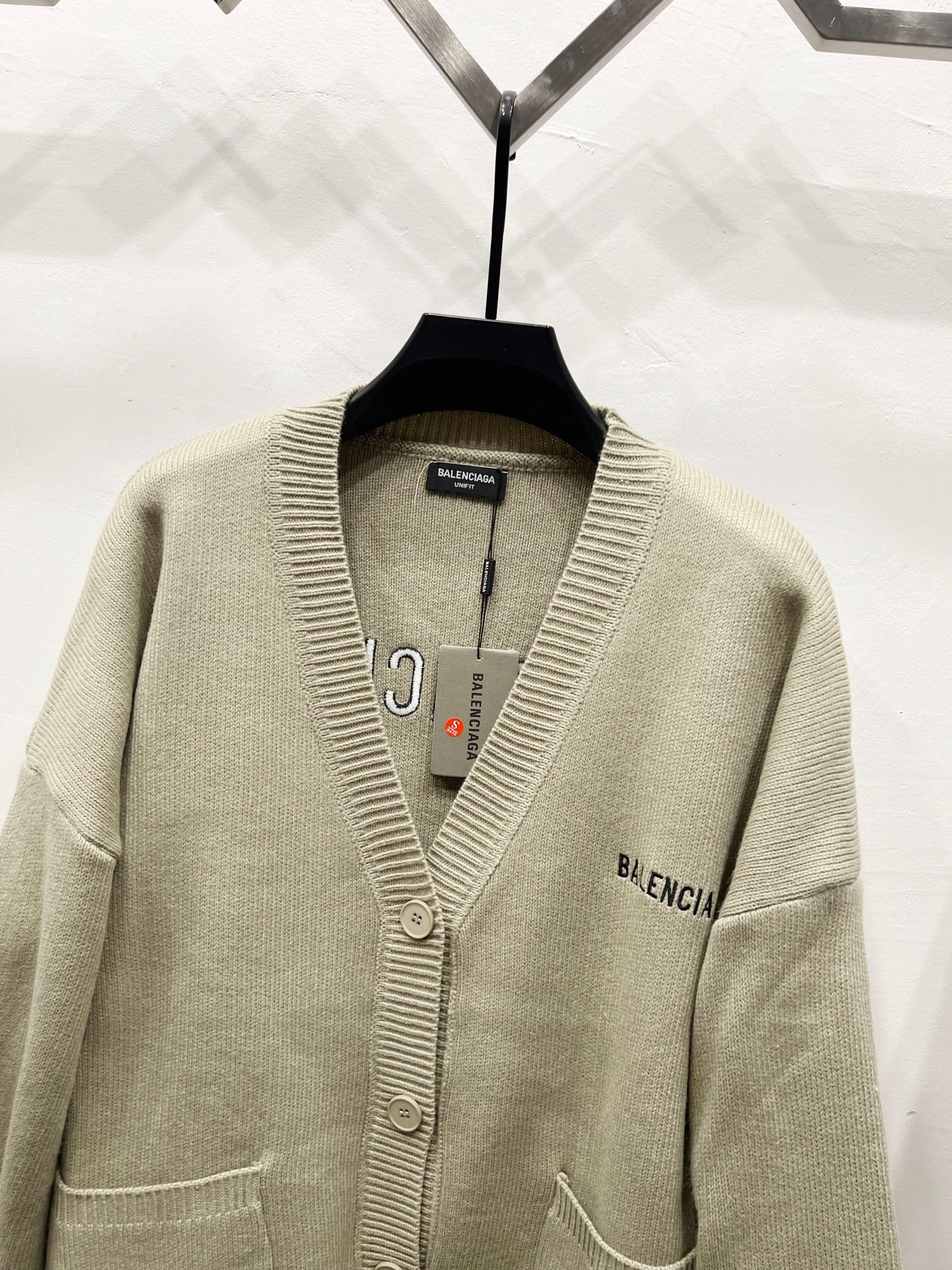 Beige V-neck knit cardigan with button placket and embroidered side logo