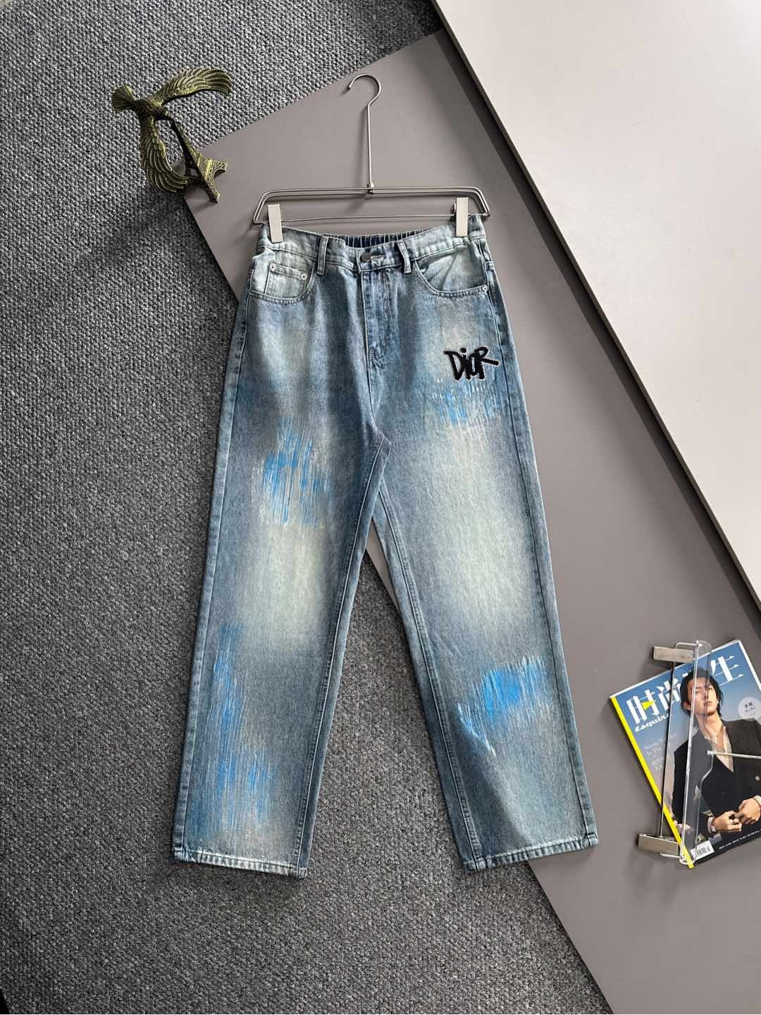 Light blue denim jeans with black logo on front, wide straight leg, belt loops