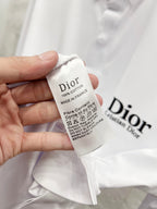 White fabric care tag with Dior branding and fiber content text