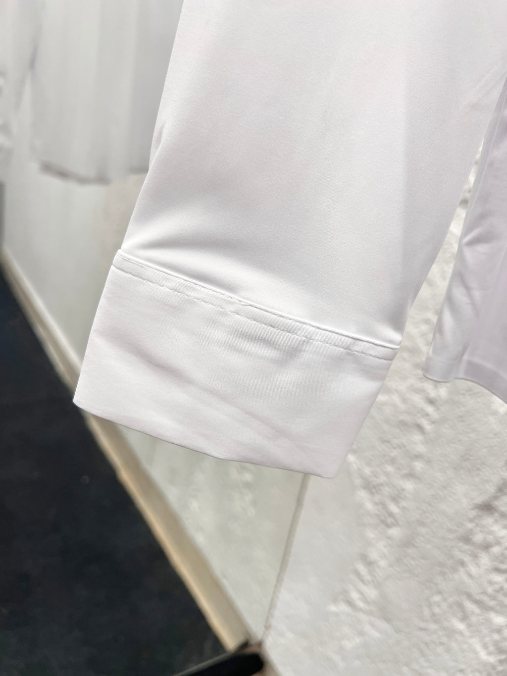 White long-sleeve shirt cuff with stitched hem seam detail