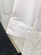 White long-sleeve shirt cuff with stitched hem seam detail
