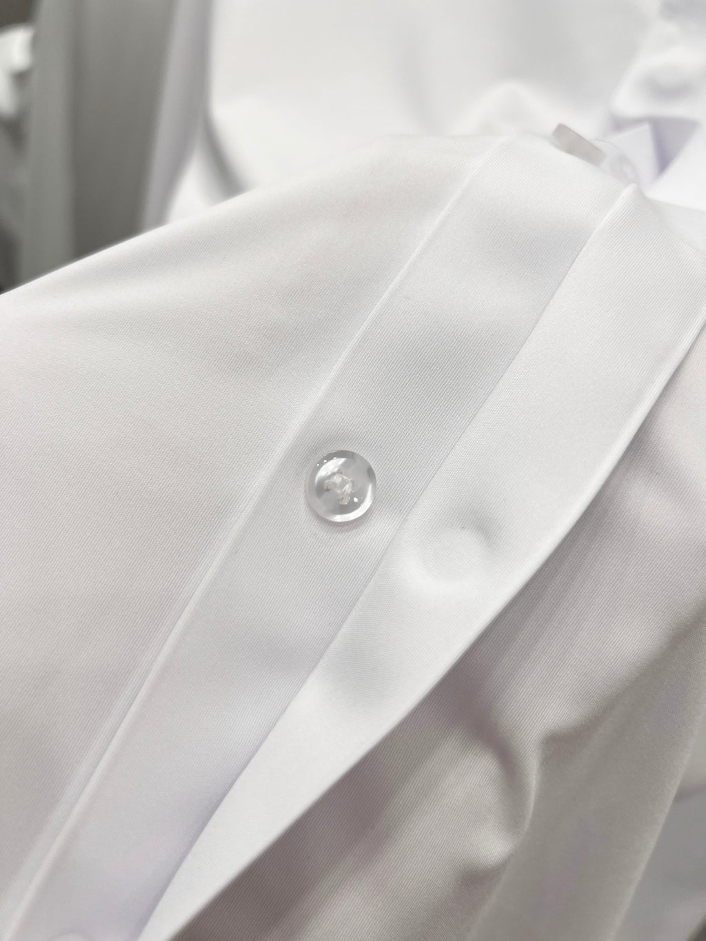 White button placket with round metal button detail on shirt