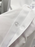 White button placket with round metal button detail on shirt