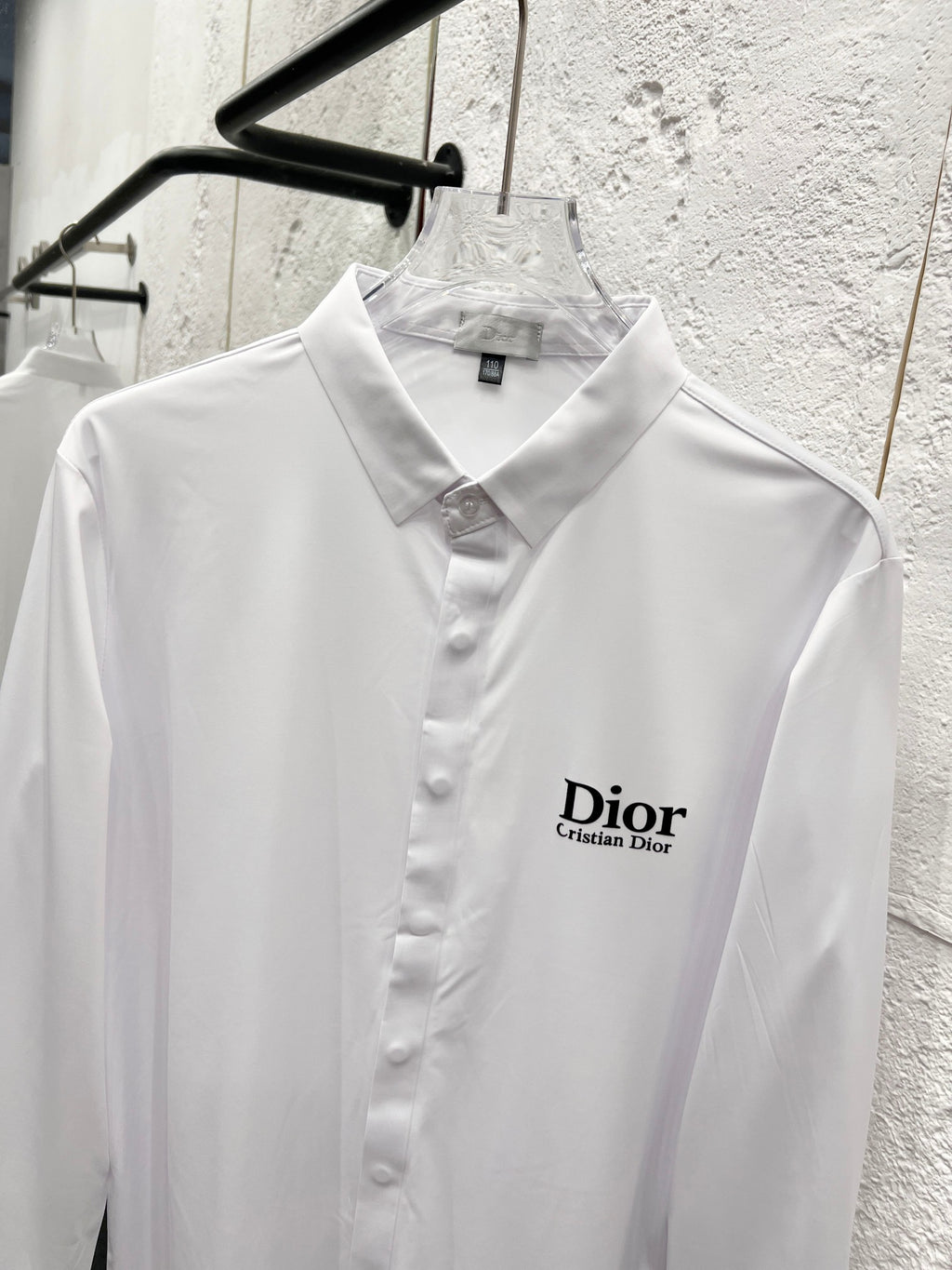 White long-sleeve button-up shirt on hanger with Dior logo