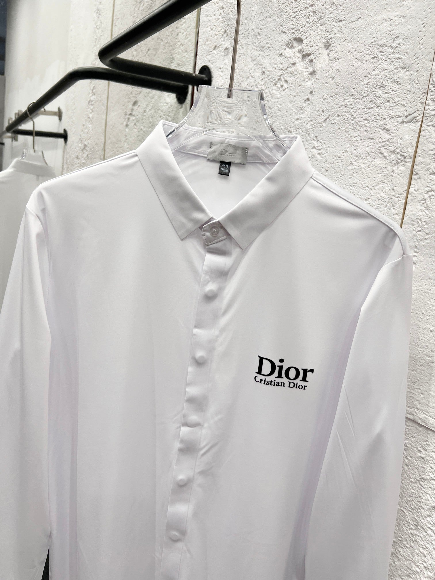 White long-sleeve button-up shirt on hanger with Dior logo