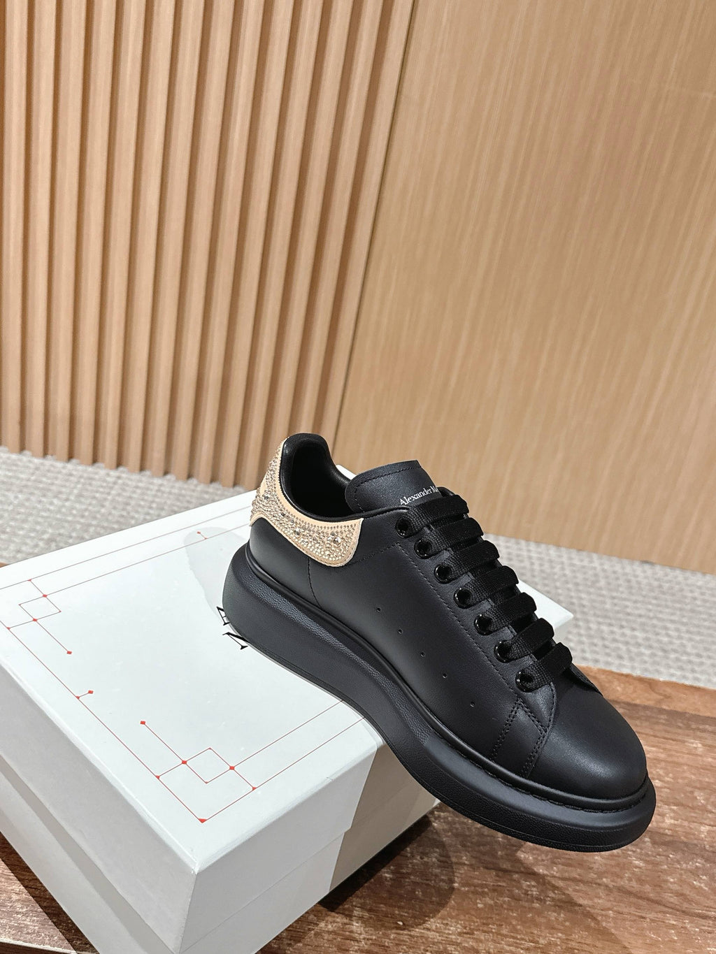 Black leather low-top sneakers with gold glitter collar detail and laces