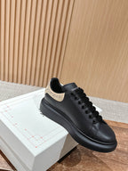 Black leather low-top sneakers with gold glitter collar detail and laces