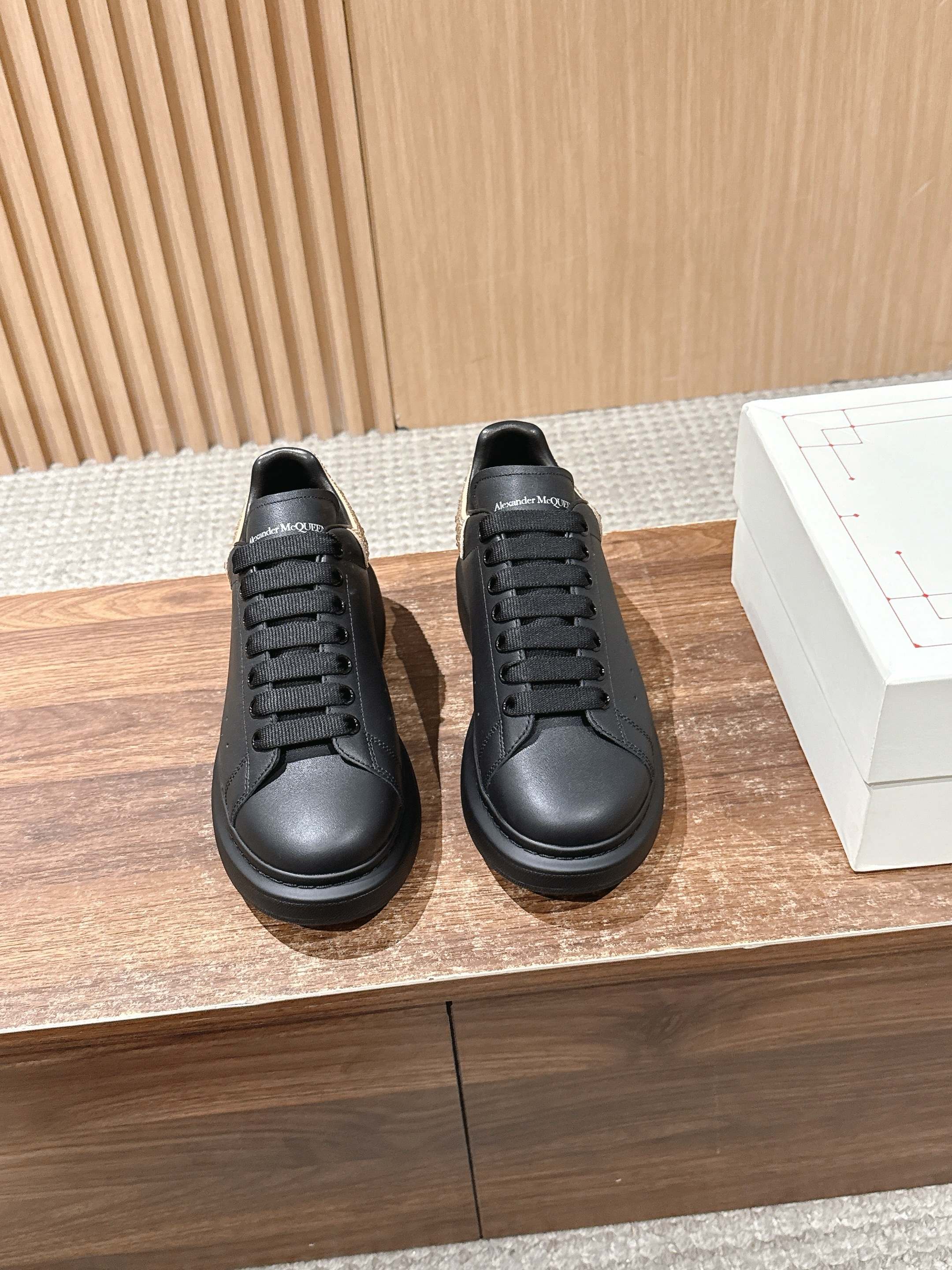 Pair of black leather lace-up sneakers with ridged rubber sole