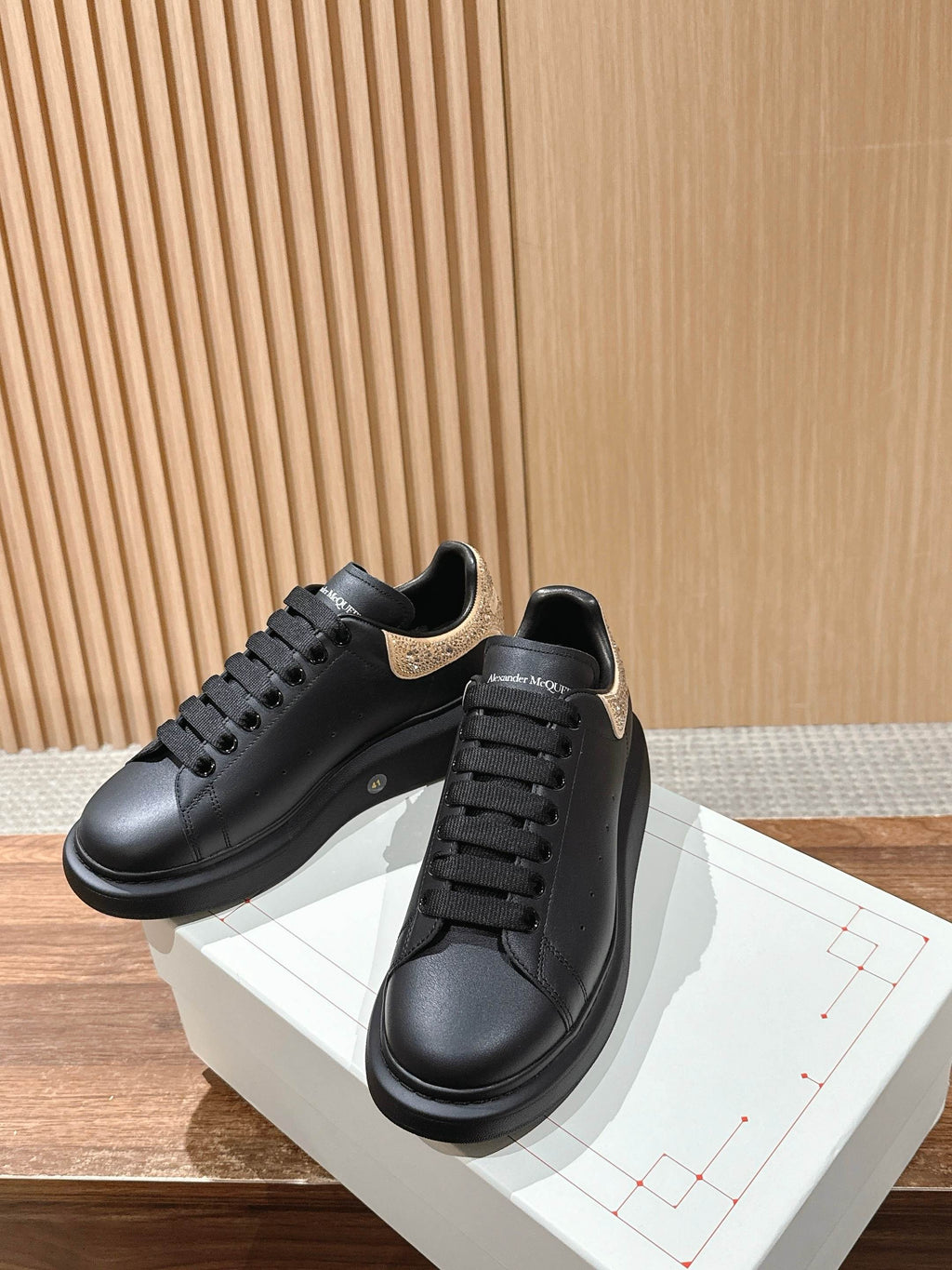 Black leather sneakers with gold glitter heel overlay, lace-up front