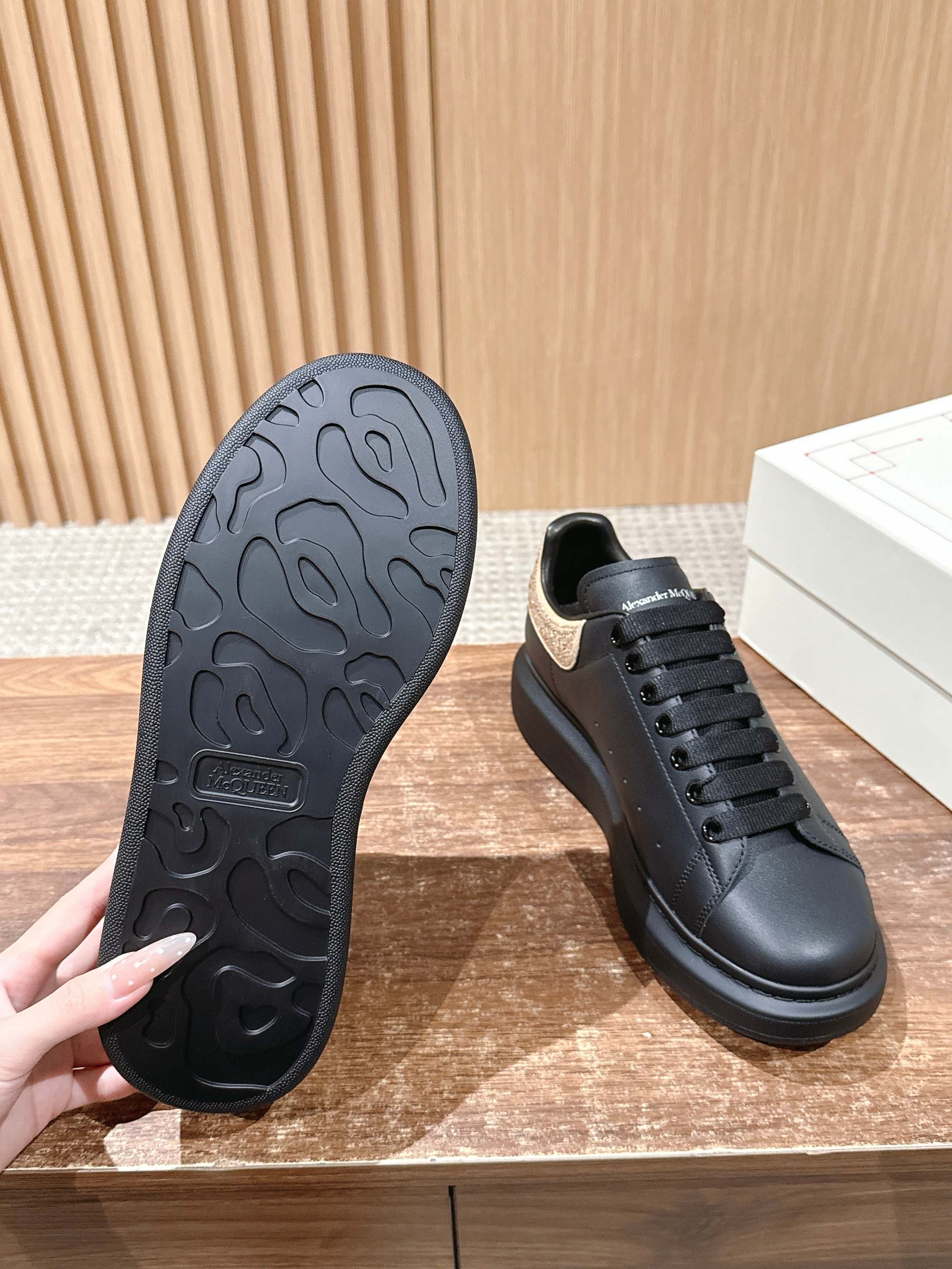 Black sneaker outsole tread shown beside low-top lace-up shoe