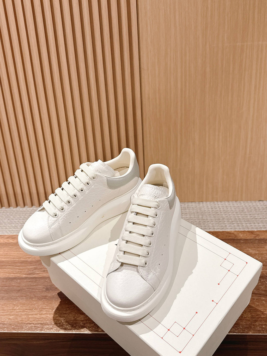 Alexander McQueen leather sneakers, white lace-up, front side view with clean stitching