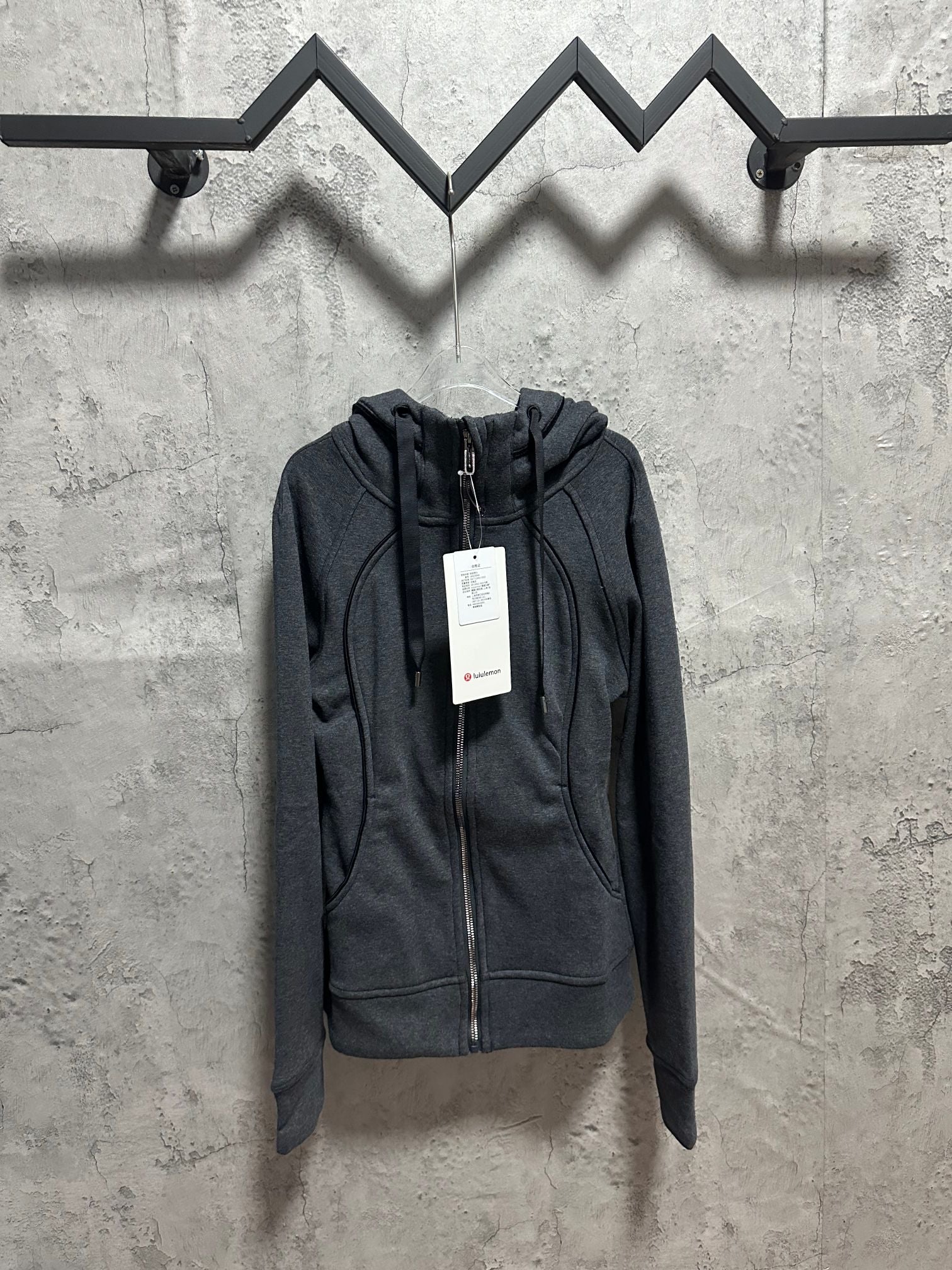 Dark gray zip-front hoodie with hood and drawstring, lululemon tag at chest