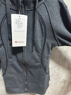 Dark gray zip-up hoodie front close-up with zipper, kangaroo pocket, and tags