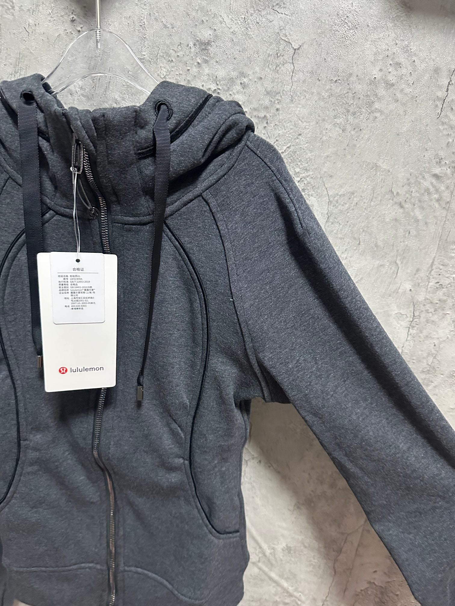 Dark gray zip-up hoodie, close-up of hood with drawstring and front zipper