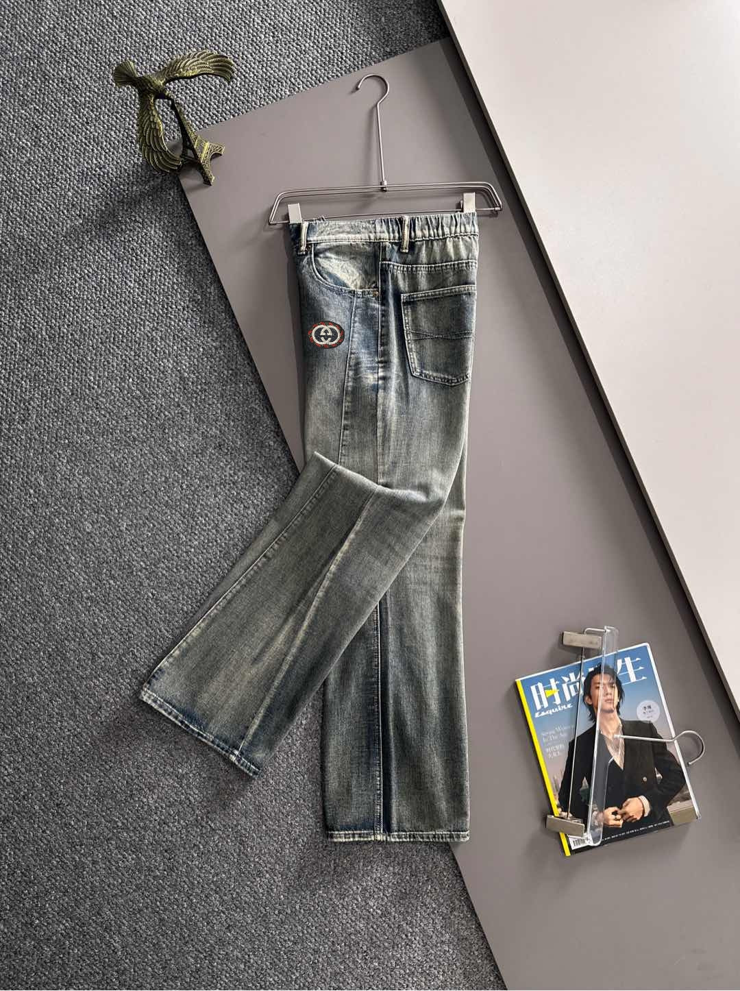 Denim pants with Gucci logo patch, front view, belt loops, button-fly