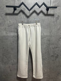Cream sweatpants with elastic waistband and drawstring, relaxed straight leg