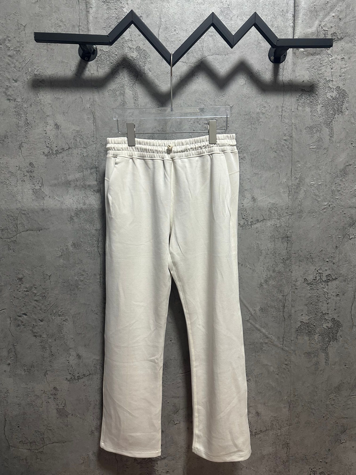 Cream sweatpants with elastic waistband and drawstring, relaxed straight leg